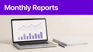 A laptop shows charts beside organized spreadsheets and a pen.